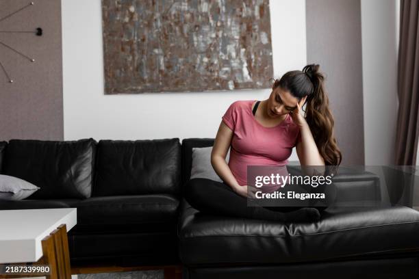 una mujer embarazada siente depresión mientras descansa en casa - incómodo fotografías e imágenes de stock