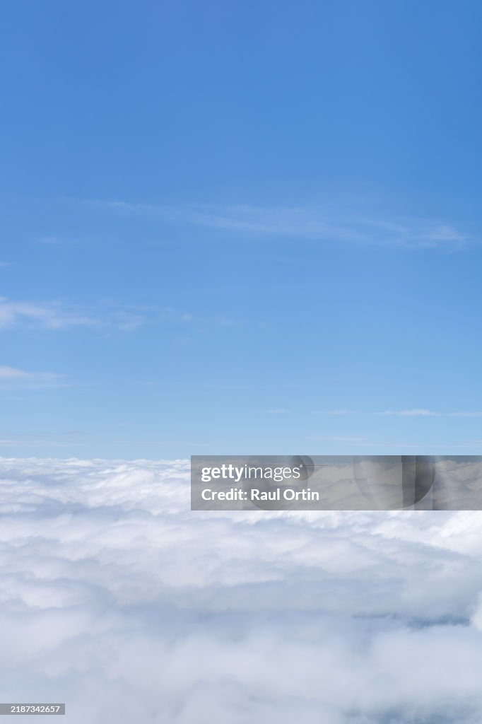 View from plane of blue sky with clouds