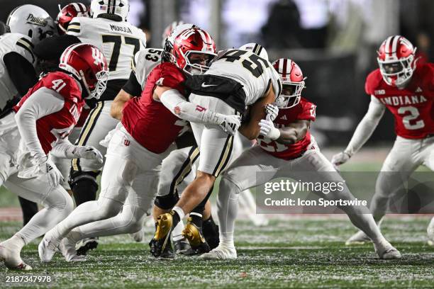 Indiana Hoosiers LB Aiden Fisher and LB Rolijah Hardy tackle Purdue Boilermakers RB Devin Mockobee during a college football game between the Purdue...
