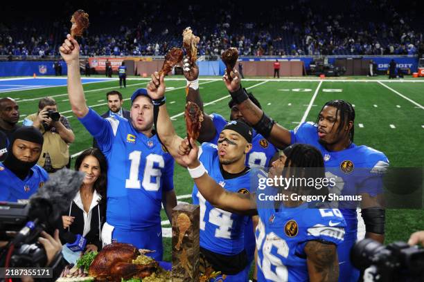 The Detroit Lions celebrate and eat turkey during a CBS interview after beating the Chicago Bears 23-20 at Ford Field on November 28, 2024 in...