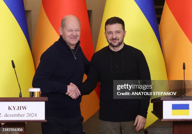German Chancellor Olaf Scholz and Ukrainian President Volodymyr Zelensky shake hands during a press conference after a meeting in Saint Sophia...
