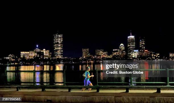 Cambridge, MA A woman jogs alongside the Charles River.