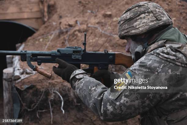 The Commander of a mobile firing team of 118th motorized brigade prepares his machine gun to go on patrol and check for drones near the front line...