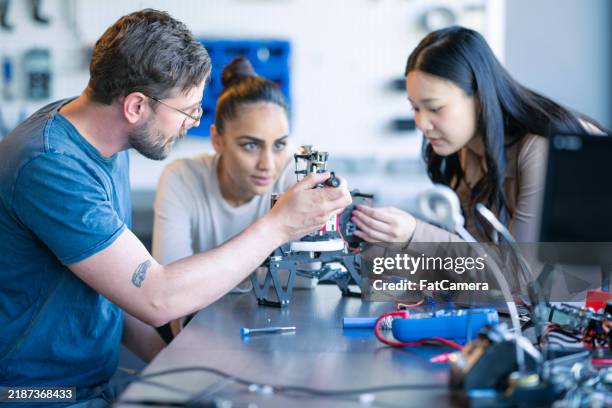 robotics technicians working together - engineering lab stock pictures, royalty-free photos & images
