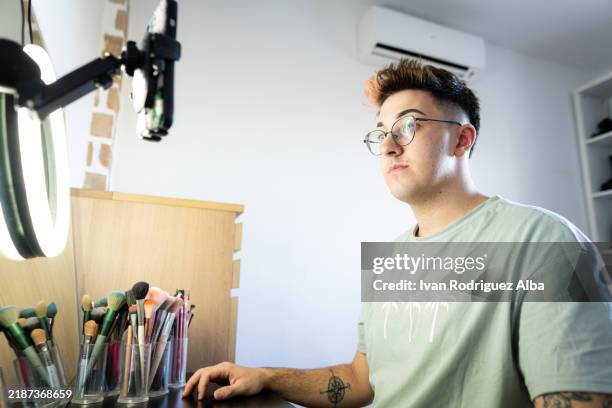 young man creating makeup tutorial using smartphone and ring light - makeup table lights stock pictures, royalty-free photos & images