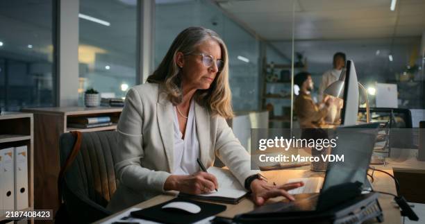 woman, night and laptop for writing notes on finance, communication and budget strategy. mature person, manager and online for investment report on stock market, accounting and feedback in office - business online banking stock pictures, royalty-free photos & images
