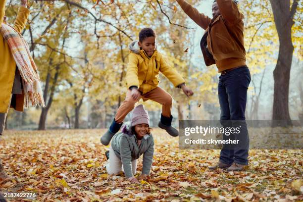 leapfrog-spiel am herbsttag! - bockspringen stock-fotos und bilder