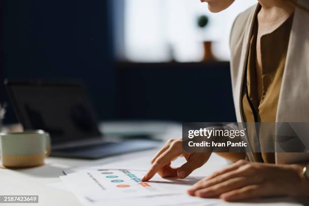 close up of a businesswoman analyzing reports in the office. - wijsvinger stockfoto's en -beelden