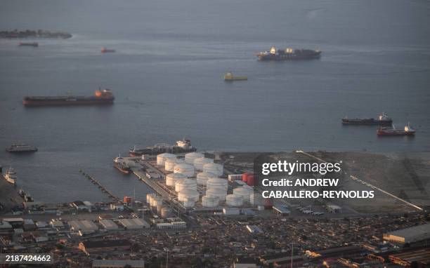 An aerial photo of cargo ships passing an oil and gas storage facility at a port in Luanda on December 2, 2024.