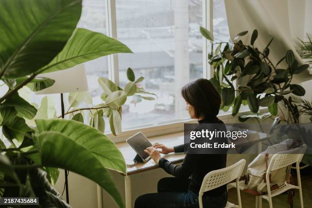 asian woman working at green apartment. - freelance work stock pictures, royalty-free photos & images
