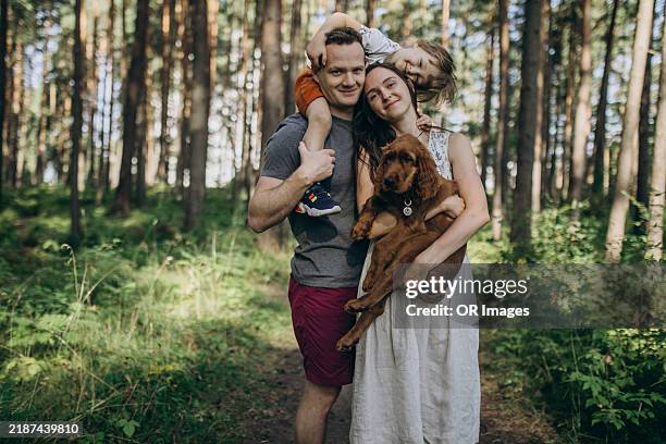 portrait of happy family with dog in a forest - eén dier stockfoto's en -beelden