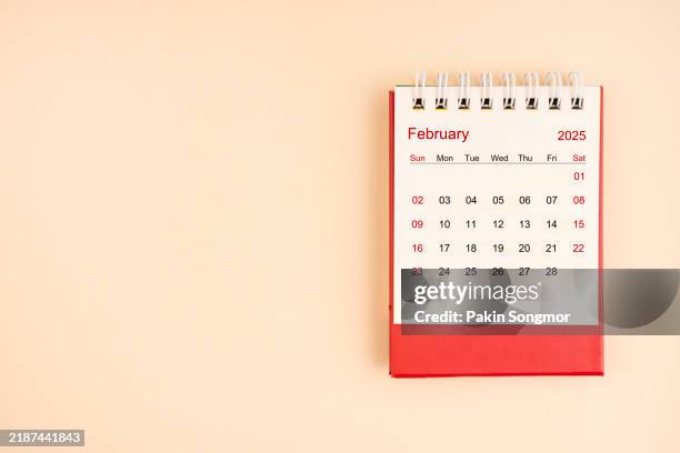 february 2025 desk calendar on yellow color background, position with copy space. - febrero fotografías e imágenes de stock