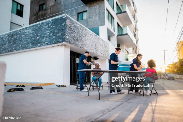 nurses vaccinating people outdoors - vaccination center stock pictures, royalty-free photos & images