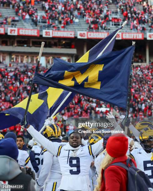 Michigan Wolverines defensive back Rod Moore walks on the field holding a Michigan flag with his teammates after the game against the Michigan...