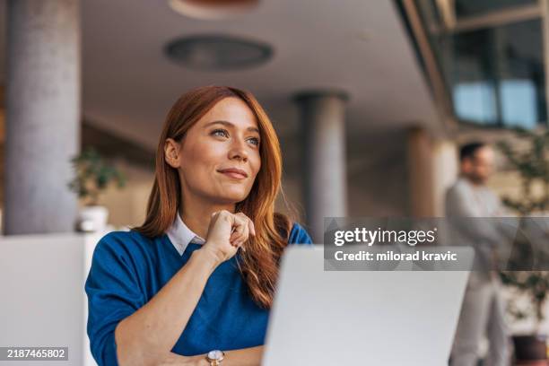 un ritratto di una donna pensierosa seduta a una scrivania in ufficio. - business woman foto e immagini stock