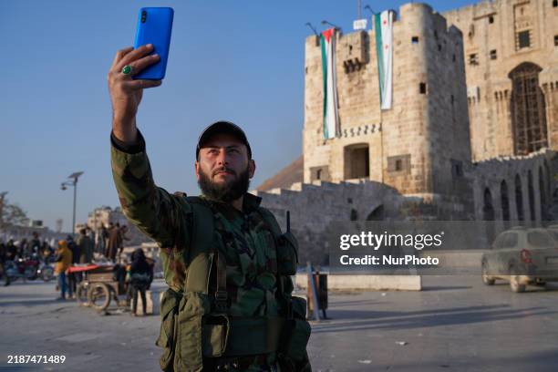 Syrian opposition fighter takes a selfie in front of the ancient citadel of Aleppo after taking control of the city in Aleppo, Syria, on December 1,...