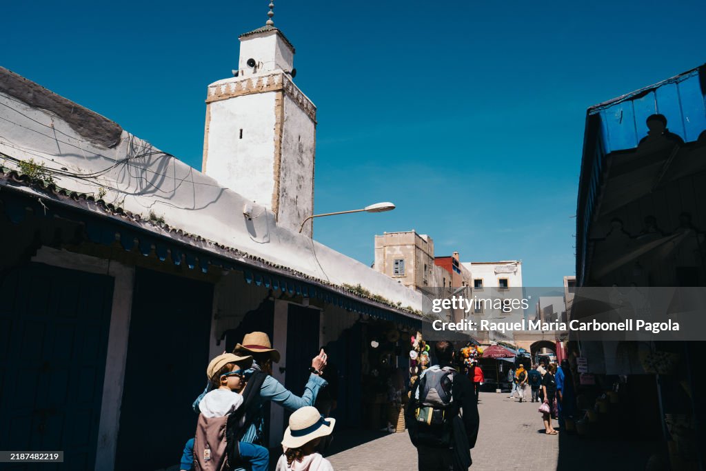 Tourists family with two kids walking by a mosque minaret in...