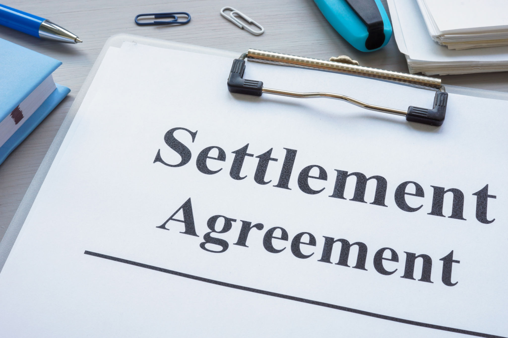 Close up of clipboard with settlement agreement. Close up of clipboard with settlement agreement.