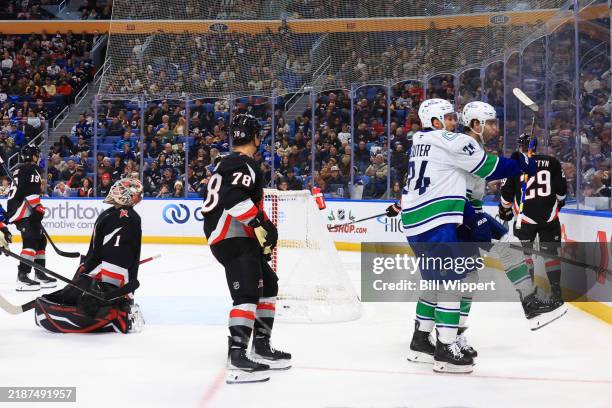 Jake DeBrusk of the Vancouver Canucks celebrates his goal against Ukko-Pekka Luukkonen of the Buffalo Sabres with Pius Suter of the Vancouver Canucks...
