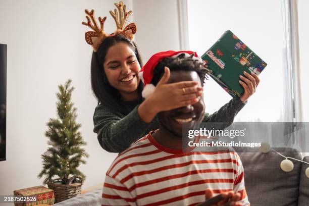 paar teilt weihnachtsgeschenk zu hause - gift lounge stock-fotos und bilder