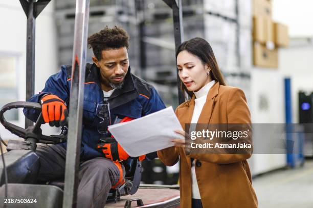 professional adult female warehouse manager sharing plans for the future operations with her best warehouse employee - chores stock pictures, royalty-free photos & images