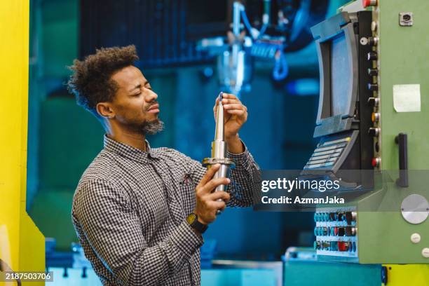 adult mixed male electrical engineer closely inspecting the tools of the cnc machine in a factory - milling cutter stock pictures, royalty-free photos & images