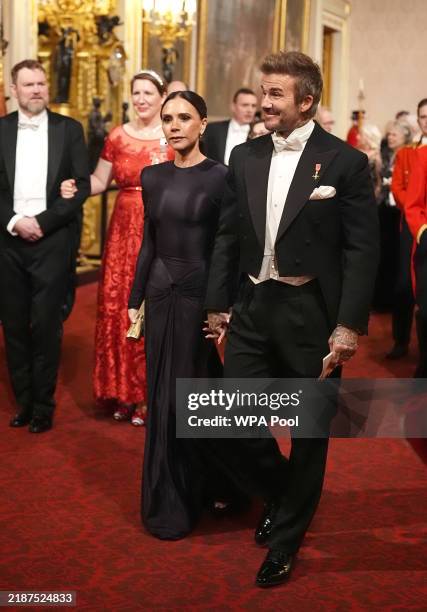 Victoria and David Beckham make their way along the East Gallery to attend the State Banquet at Buckingham Palace during day one of The Amir of the...