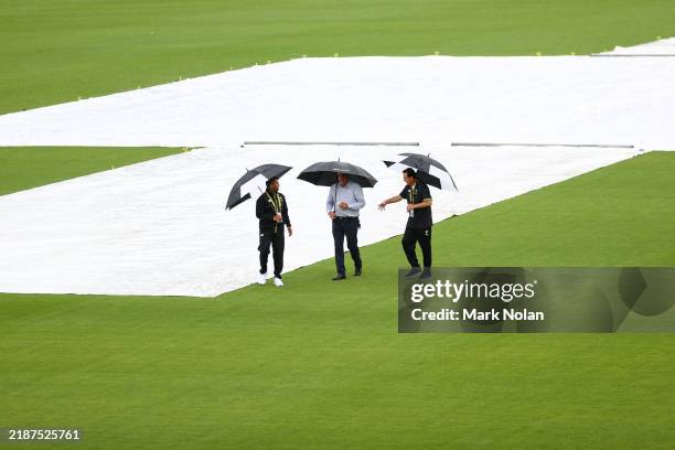 Match officials inspect the pitch as rain delays day one of the tour match between Prime Minister's XI and India at Manuka Oval on November 30, 2024...
