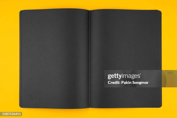 top view of opened blank black color notepad on yellow background. - blank pages in open book overhead view stock pictures, royalty-free photos & images