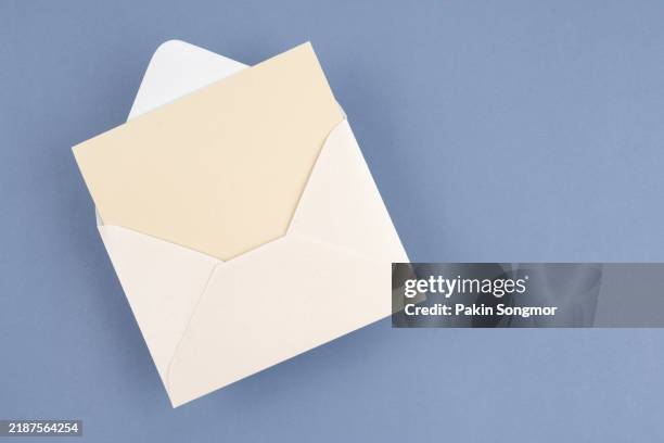 envelope with empty white sheet of paper, empty template. light blue background. - envelop stockfoto's en -beelden