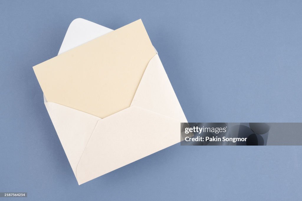 Envelope with empty white sheet of paper, empty template. Light blue background.