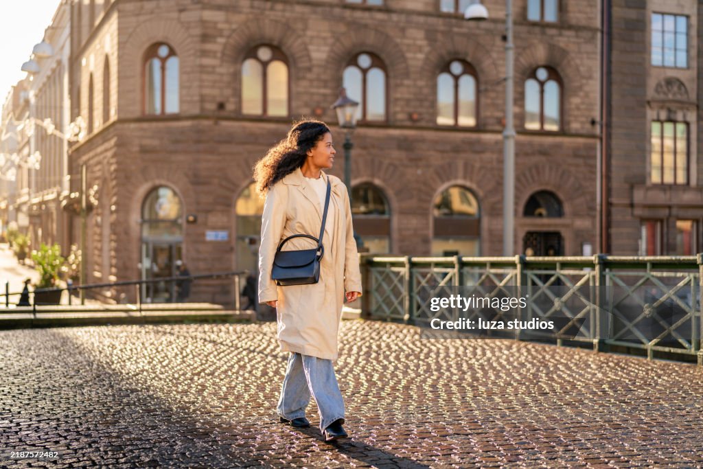 Happy woman tourist walking on bridge in city