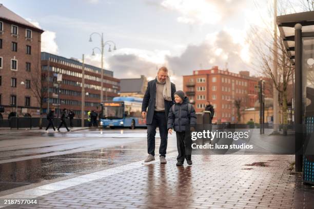 happy father and son talking and walking on sidewalk in scandinavian city - göteborg stad bildbanksfoton och bilder
