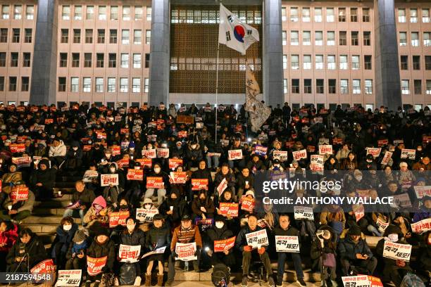 People call for the resignation of South Korea President Yoon Suk Yeol as they take part in a protest on the steps leading to the National Assembly...