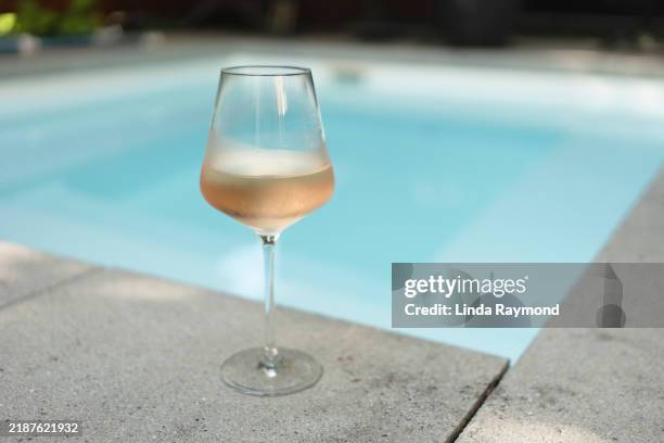 glass of wine by the swimming pool - blush wine stock pictures, royalty-free photos & images