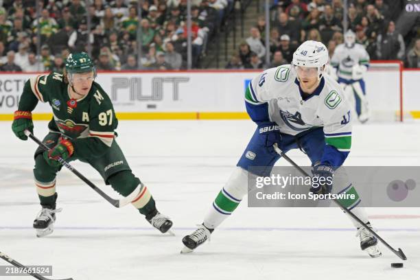 Vancouver Canucks forward Elias Pettersson looks to shoot as Minnesota Wild forward Kirill Kaprizov gives chase during an NHL game between the...