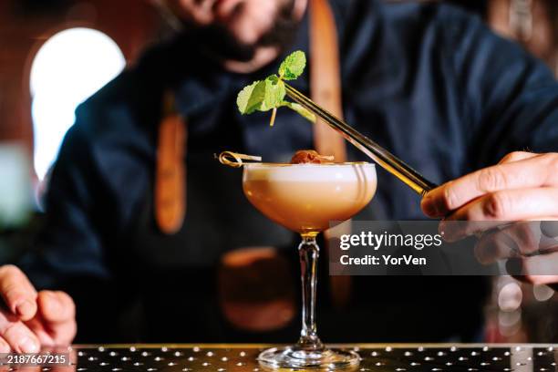 primo piano di un barista che guarnisce un cocktail daiquiri nel pub - happy hour foto e immagini stock