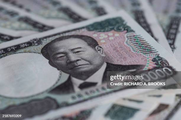 This photo illustration taken on December 5, 2024 shows new Japanese 10,000 yen notes , which were released in July 2024 with a portrait of financier...
