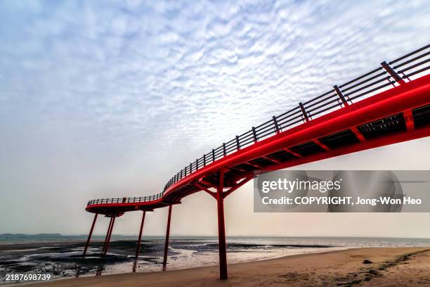 red elevated walkway over beach towards sea - província de chungcheong do sul imagens e fotografias de stock