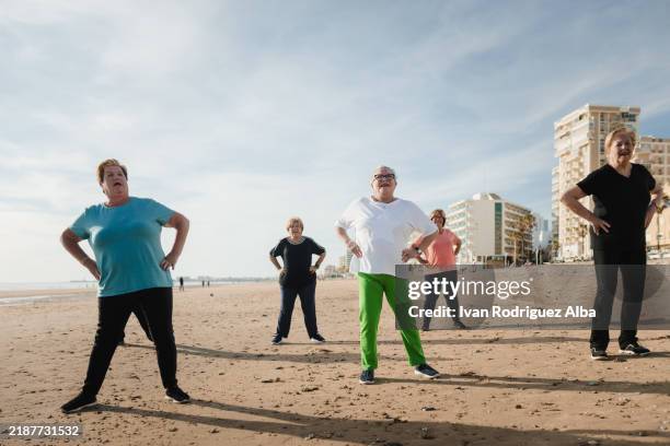 group of senior adults doing gymnastics on the beach - pacific rim gymnastics stock pictures, royalty-free photos & images