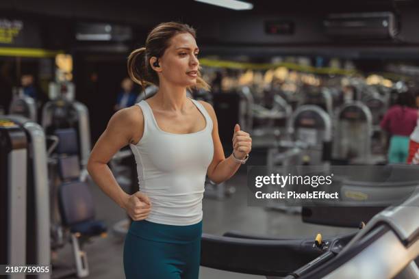 entrenamiento cardiovascular: mujer corriendo en la cinta de correr del gimnasio para un corazón sano - centro de bienestar fotografías e imágenes de stock