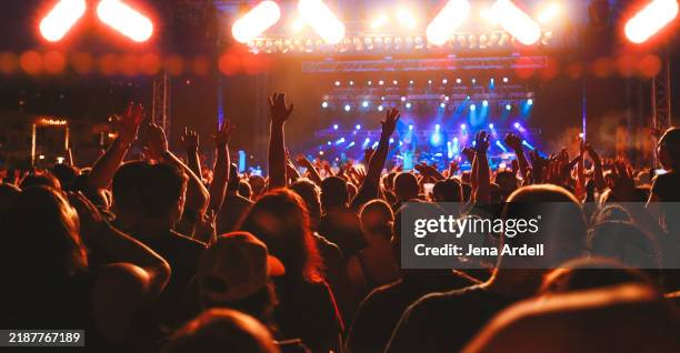 concert crowd arms raised, audience cheering, live music event - konzerthaus stock-fotos und bilder