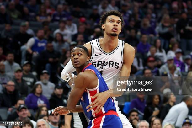 Victor Wembanyama of the San Antonio Spurs and De'Aaron Fox of the Sacramento Kings go for a rebound in the first half at Golden 1 Center on December...