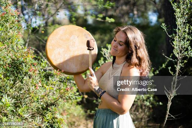 woman playing a native american drum outdoors in nature - traditional native american medicine stock pictures, royalty-free photos & images
