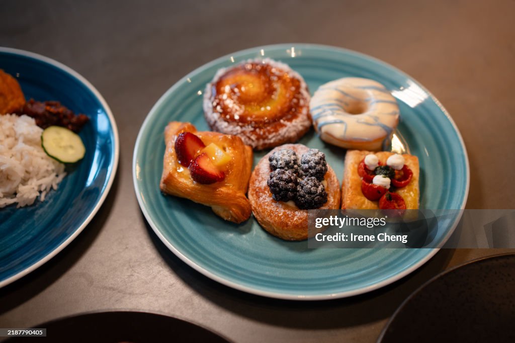 Various types of Danish pastries served on a plate on a wooden table.