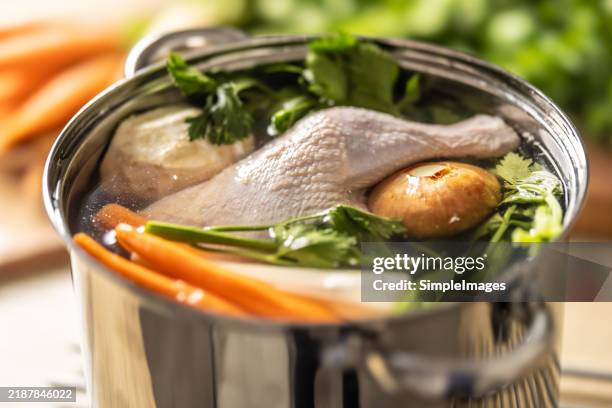 raw ingredients immersed in a pot ready to cook chicken broth - fond stockfoto's en -beelden