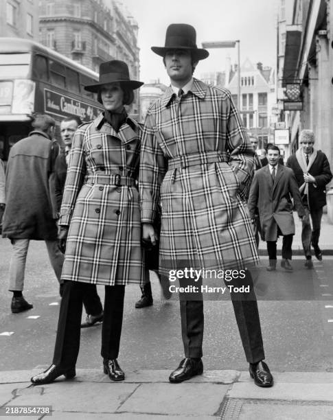 Two models wearing 'Westpoint' and 'Rider' cotton coats on show at a preview of Burberry's 1970 Autumn Collection in London, 6th March 1970. The...