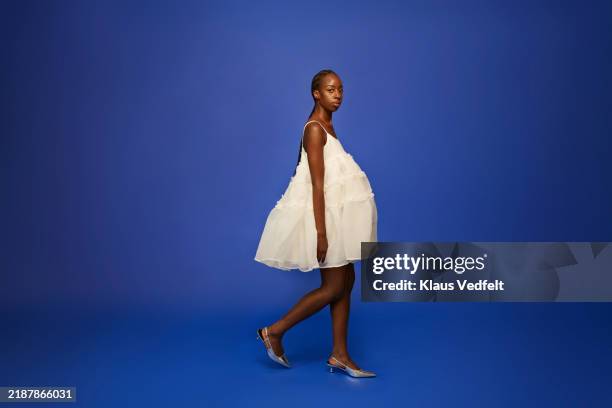 young woman walking in white dress - dress stock pictures, royalty-free photos & images
