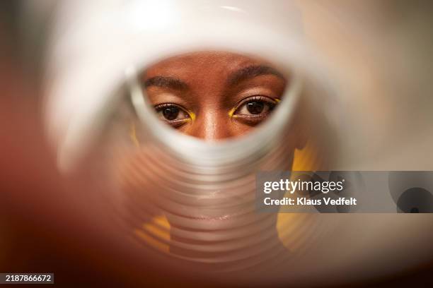 young woman looking through silver translucent pipe - see through stock pictures, royalty-free photos & images