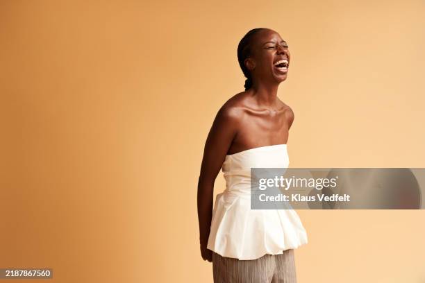 happy young woman wearing white off shoulder top - black dress stock pictures, royalty-free photos & images